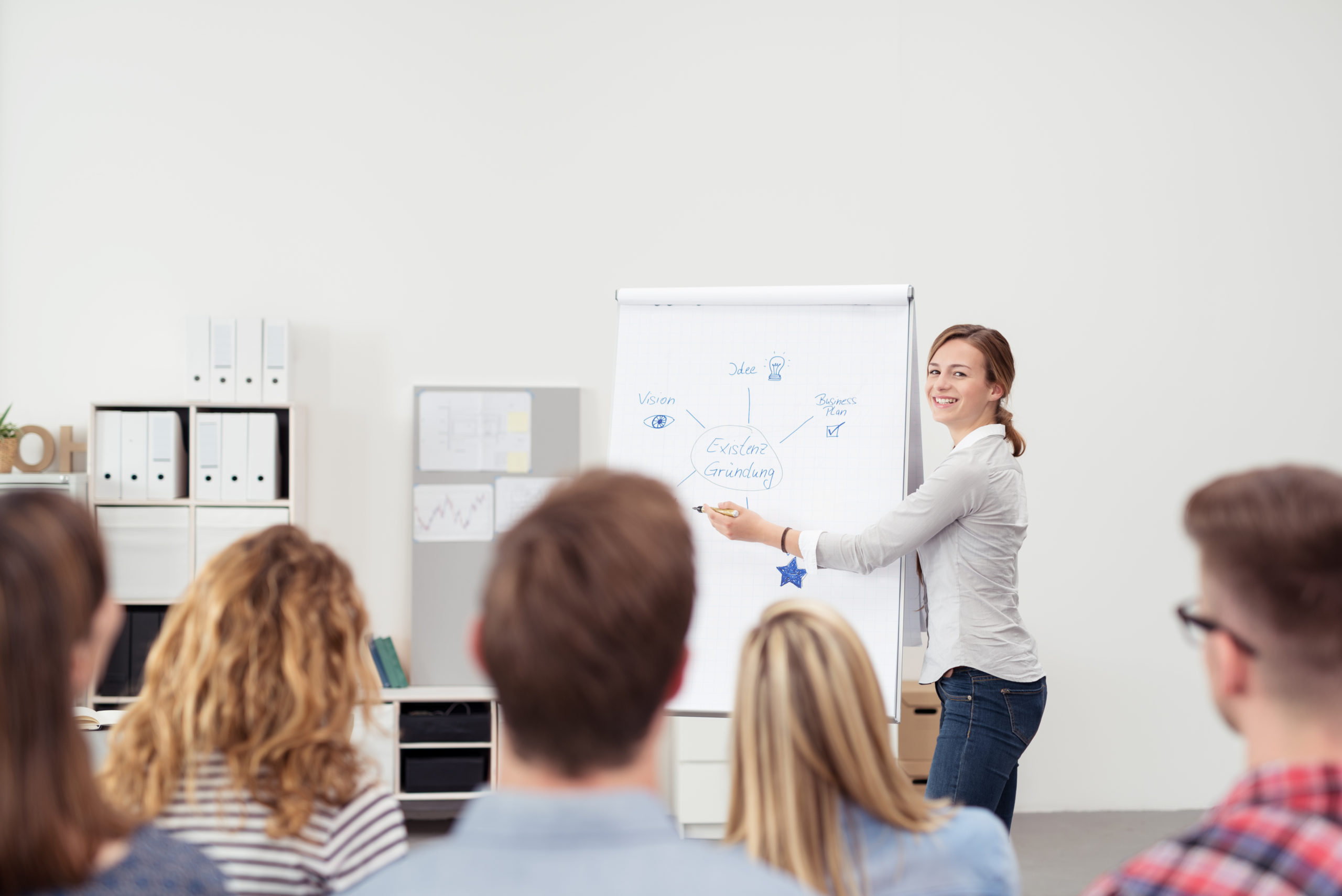 Femme avec un tableau expliquant un cours à des élèves